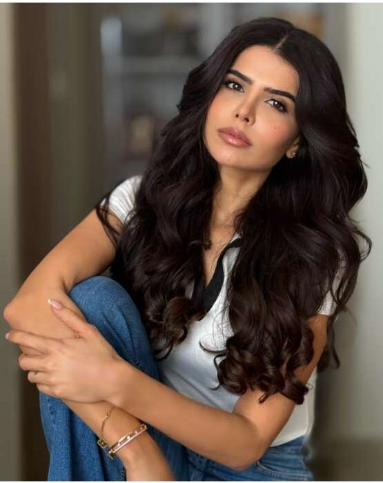 Hind Achahbar engaging with her audience or posing thoughtfully, representing the blend of intelligence and elegance that defines her fashion and lifestyle content.